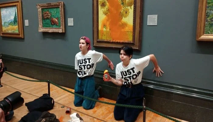 Activists from "Just Stop Oil" attach their hands to the wall after pouring soup at a van Gogh artwork titled "Sunflowers" at the National Gallery in London, England, on October 14, 2022. — According to Reuters