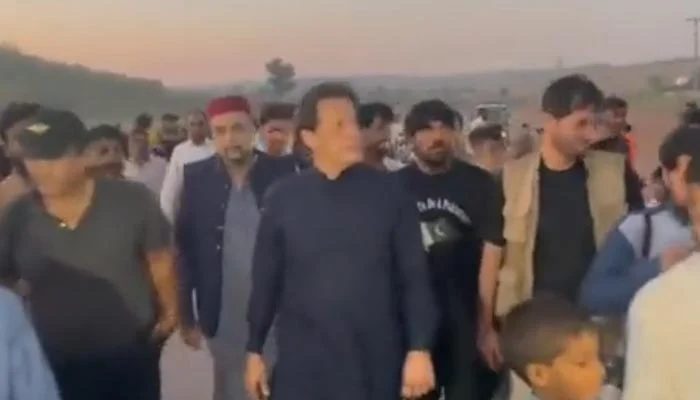On October 8, 2022, PTI chairman and former Prime Minister Imran Khan walks towards Bani Gala after his chopper made an emergency landing at Adiala prison. — From Twitter