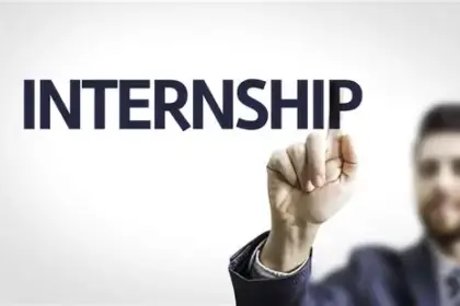 A businessman in a suit pointing at the word “INTERNSHIP” on a transparent screen, symbolizing career opportunities and training programs.
