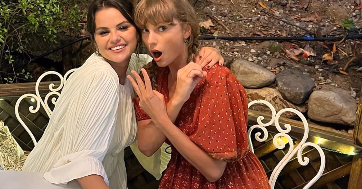 Taylor Swift and Selena Gomez smiling and posing together at an outdoor table, showing their close friendship.