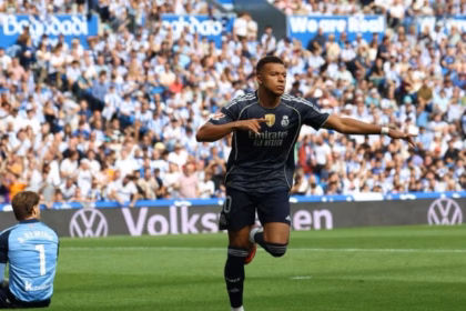Kylian Mbappe celebrates after scoring for Real Madrid against Real Sociedad in LaLiga 2025/26 at the Reale Arena, with Arda Guler and teammates joining the celebrations.