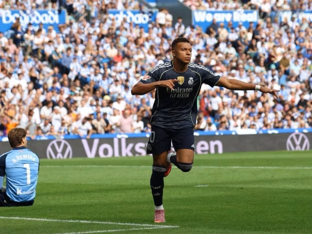Kylian Mbappe celebrates after scoring for Real Madrid against Real Sociedad in LaLiga 2025/26 at the Reale Arena, with Arda Guler and teammates joining the celebrations.